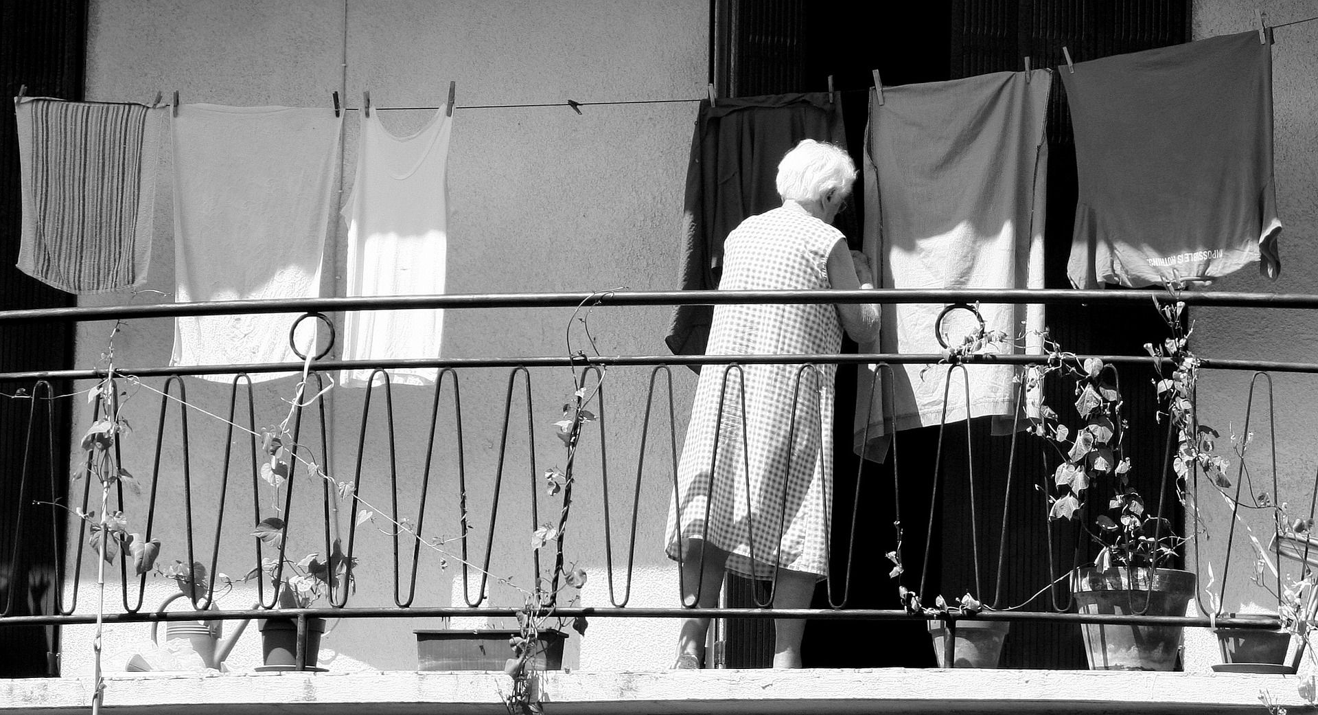 Alte Frau beim Wäsche aufhängen